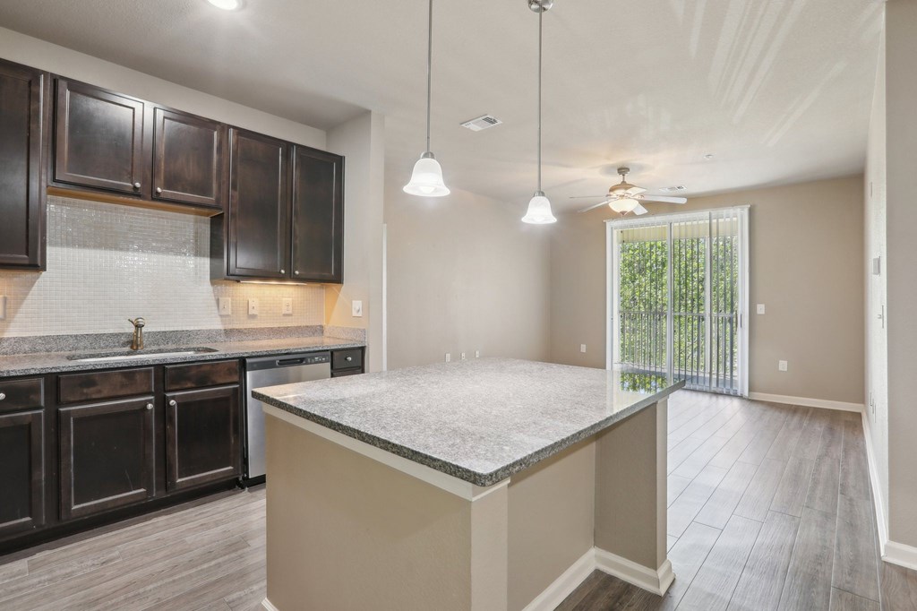 Model kitchen with dark brown cabinets and a granite countertop.