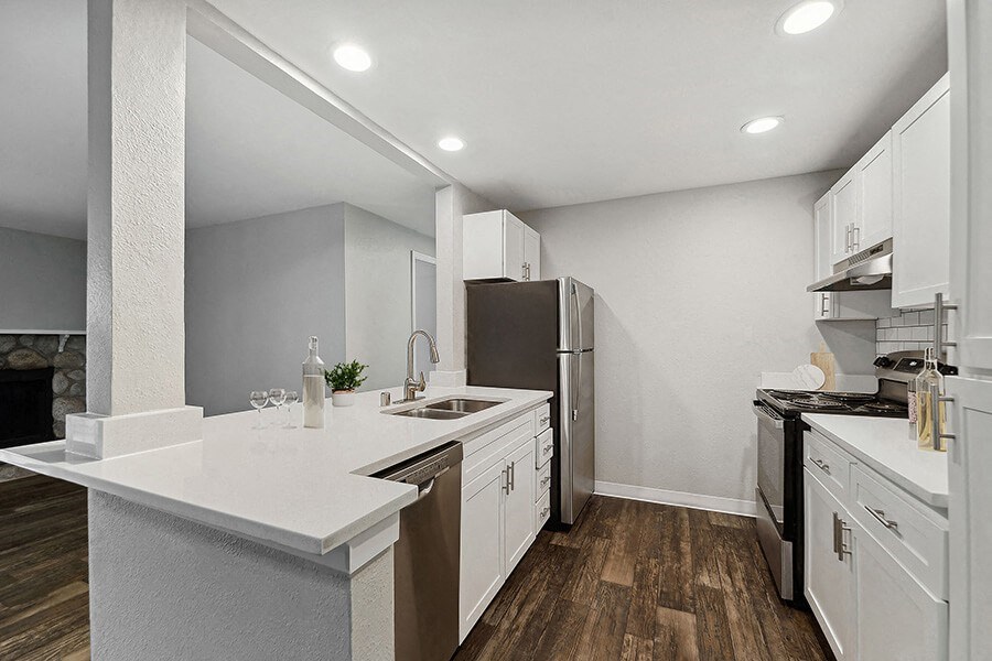 Model Kitchen with White Cabinets and Wood-Style Flooring at Central Flats Apartments in Kent, WA.