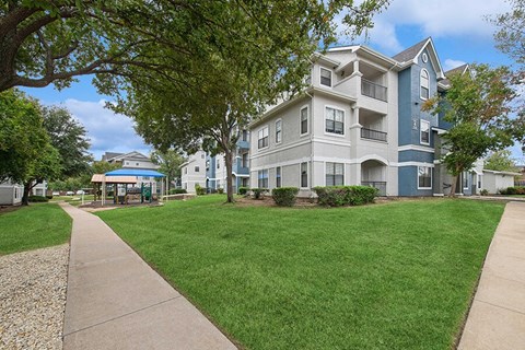Exterior Community Building and Landscape at Hidden Creek Apartments located in Lewisville, TX.