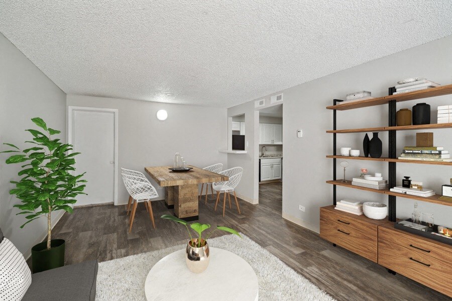 a dining area with a table and chairs and a kitchen in the background