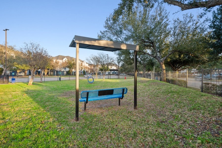 Fenced-in dog park with agility equipment at Park West Apartments in Houston, Texas