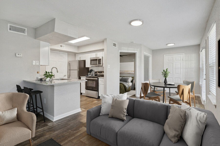 the living room and kitchen of an apartment with a couch and a table