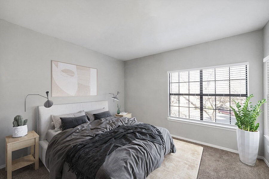 Model Bedroom with Carpet and Window View at Bridges at Oakbend Apartments located in Lewisville, TX.