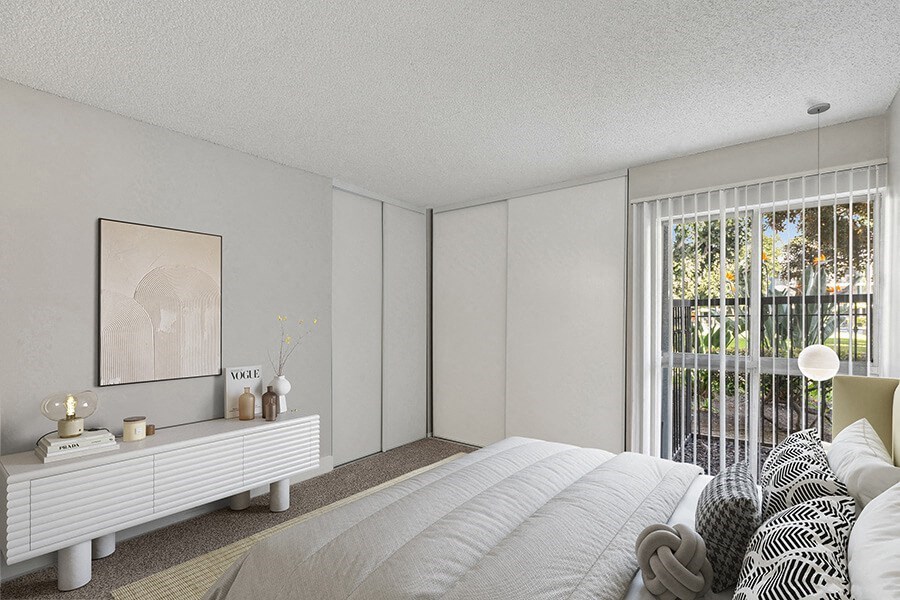 Model Bedroom with Carpet and Patio Accessibility at Madison Park Apartments located in Anaheim, CA.