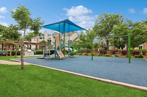 Community Playground with a Slide, Blue Canopy and Swing Set at Park 2300 Apartments in Charlotte, NC.