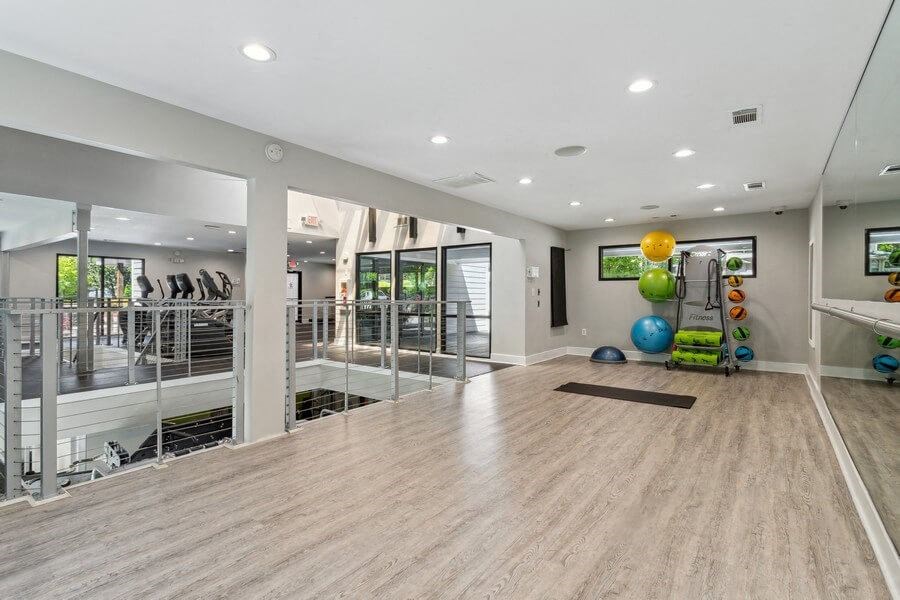 Community Fitness Center with Yoga Area and Wall Mirrors at Dunwoody Village Apartments in Atlanta, GA.