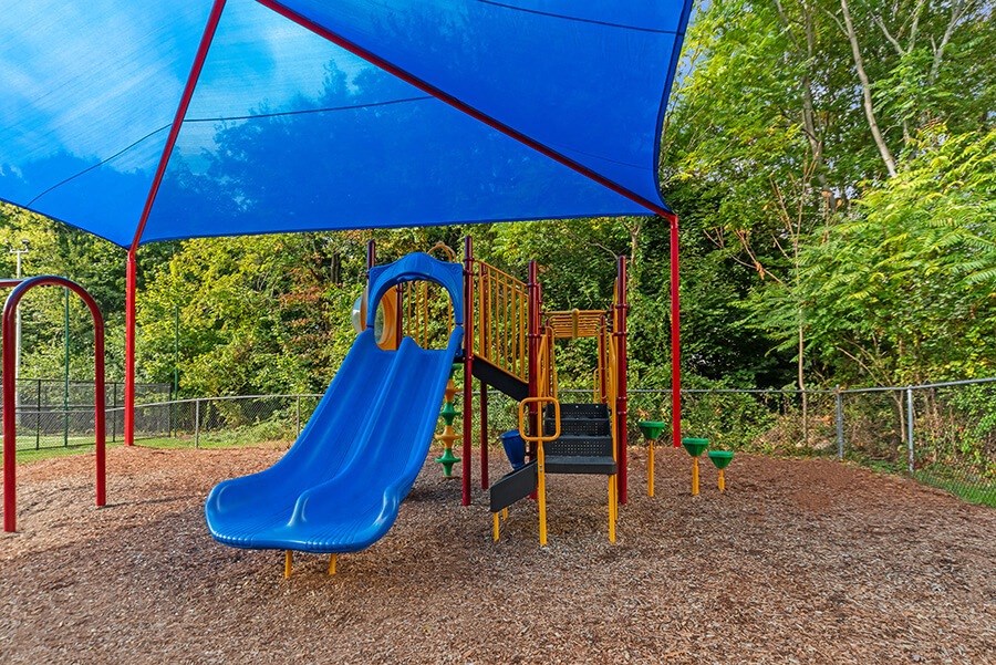 Community Playground with Slide and Blue Canopy at Heights at Marlborough Apartments located in Marlborough, MA.