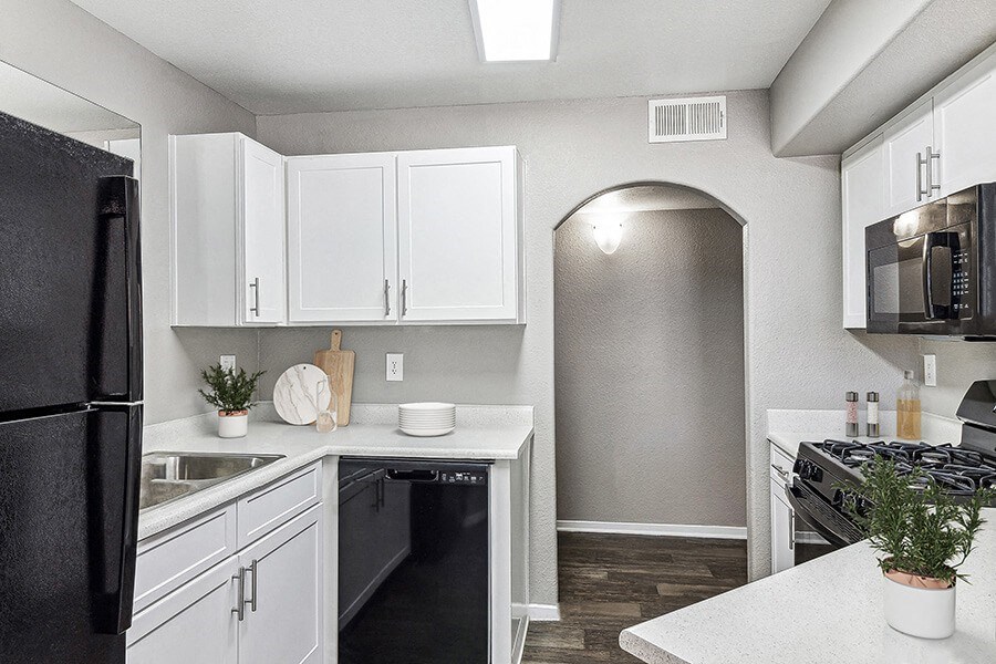 Model Kitchen with White Cabinets and Wood-Style Flooring at Topaz Springs Apartments in Las Vegas, NV.