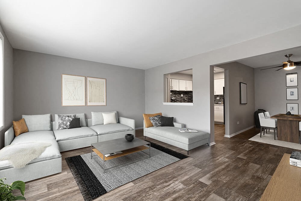 Model Living Room with Wood-Style Flooring and View of Kitchen/Dining Area at Midpointe Apartments in Chicago, IL.