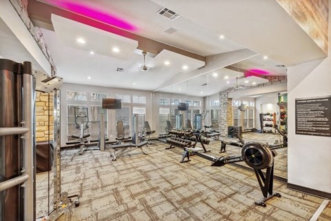 North Dallas, TX Apartments Near Lewisville Lake - Essence North Dallas - Spacious Fitness Center With Free Weights, Weight Machines, Rowing Machine, Wall Mirrors, And Large Windows.