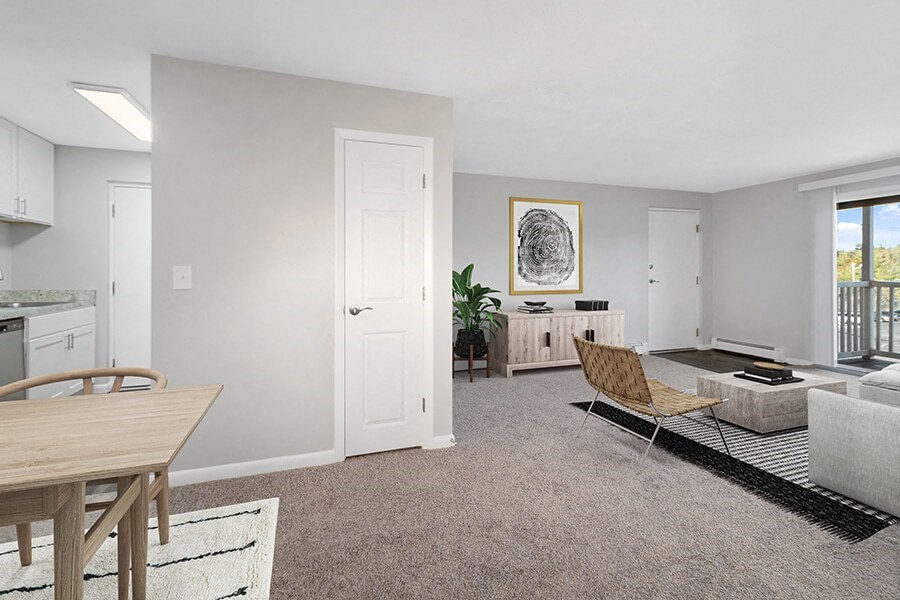 Model Living Room with Carpet and Patio Accessibility at Stone Ends Apartments in Stoughton, MA.