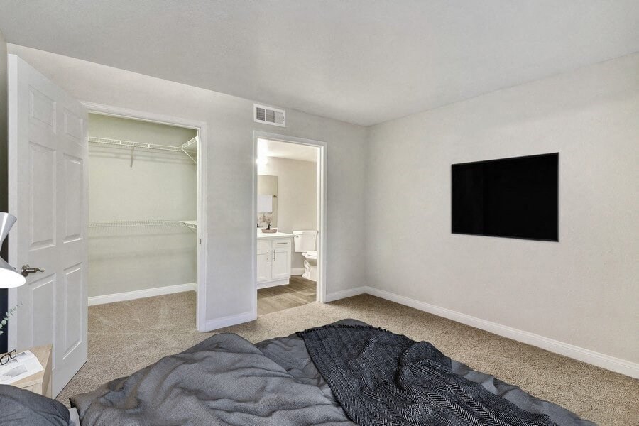 Model bedroom with a bed and a television on the wall
