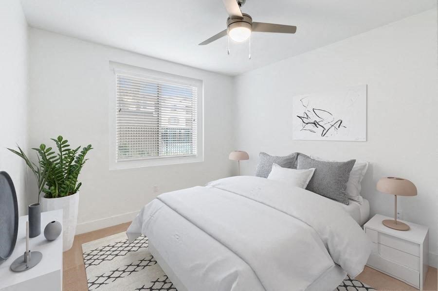 Model bedroom with queen bed and carpeting