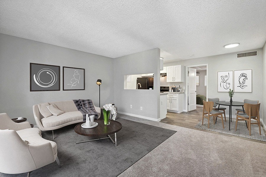 Model Living Room with Carpet and View of Kitchen/Dining Area at Stillwater Apartments in Glendale, AZ.