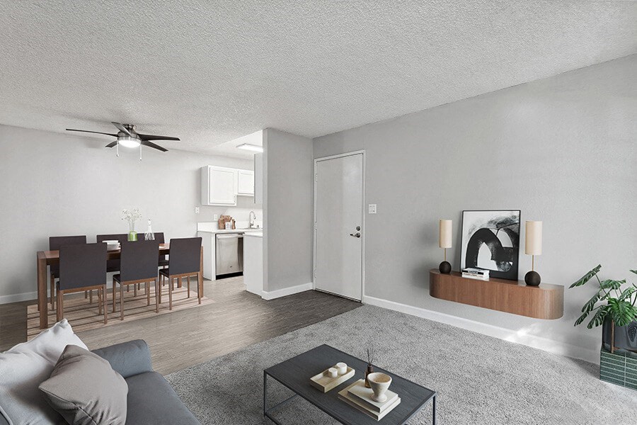 Model Living Room with Carpet and View of Dining Room with Wood-Style Flooring at The Archer Apartments in Sacramento, CA.