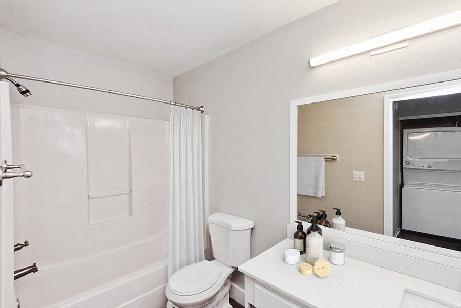Model Bathroom with White Cabinets, Wood-Style Flooring and Shower/Tub at Vue at Baymeadows Apartments in Jacksonville, FL.