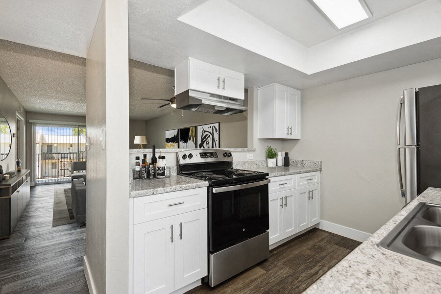 a kitchen with white cabinets and a black stove top oven a kitchen with white cabinets and a black stove top oven at Villages at Metro Center, Arizona, 85051