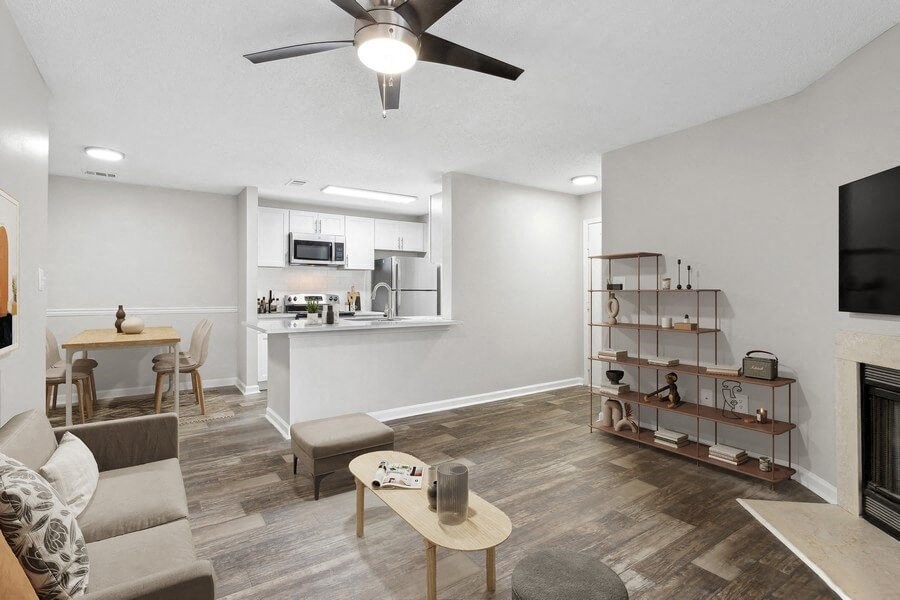 Model Living Room With Wood-Style Flooring, a Fireplace and Kitchen View at Element 41 Apartments in Marietta, GA.
