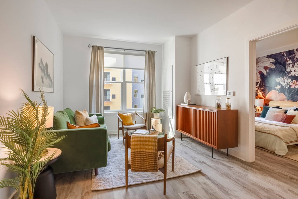 Model living room with a lot of pillows and chairs and a window