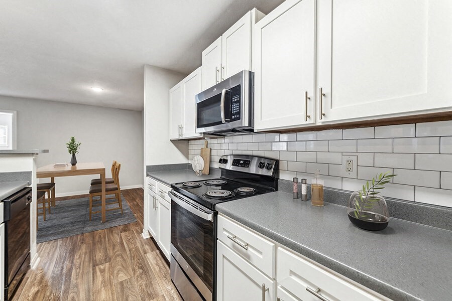 Model Kitchen with White Cabinets and Wood-Style Flooring at Lake Cameron Apartments located in Apex, NC.