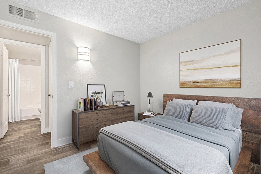 Model Bedroom with Wood-Style Flooring and attached Bathroom at Peaks on 4th Apartments in Avondale, AZ.