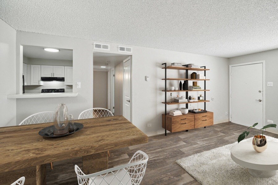 a dining room with a table and chairs and a kitchen in the background