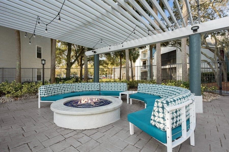 Covered Outdoor Fire Pit Area with Cushioned Patio Furniture at Caribbean Breeze Apartments in Tampa, FL.