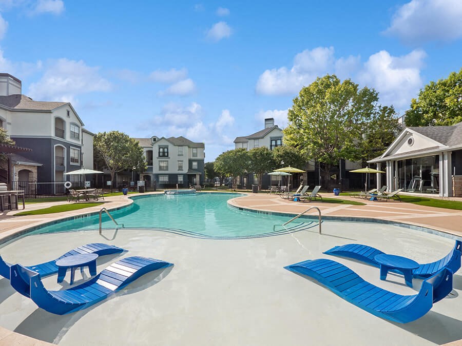 Community Swimming Pool with Pool Furniture at Park West Apartments located in Houston, TX.