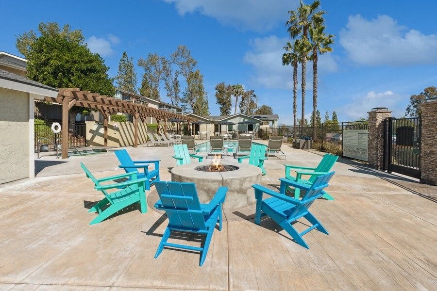Community Fire Pit surrounded with Blue Chairs at Forest Park Apartments in El Cajon, CA.