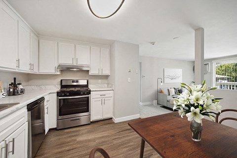 a kitchen with white cabinets and stainless steel appliances