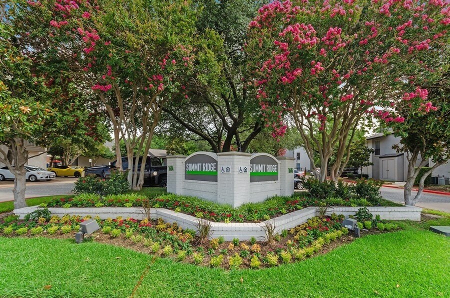 Property entrance sign showcasing well kept landscape