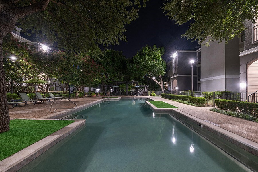 Community Swimming Pool with Pool Furniture at Bridges at Oakbend Apartments located in Lewisville, TX.