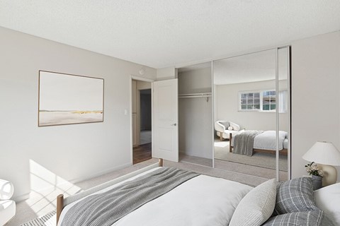 A bedroom with a large bed and a mirror on the wall.