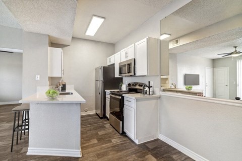 a kitchen with white cabinets and a stainless steel refrigerator