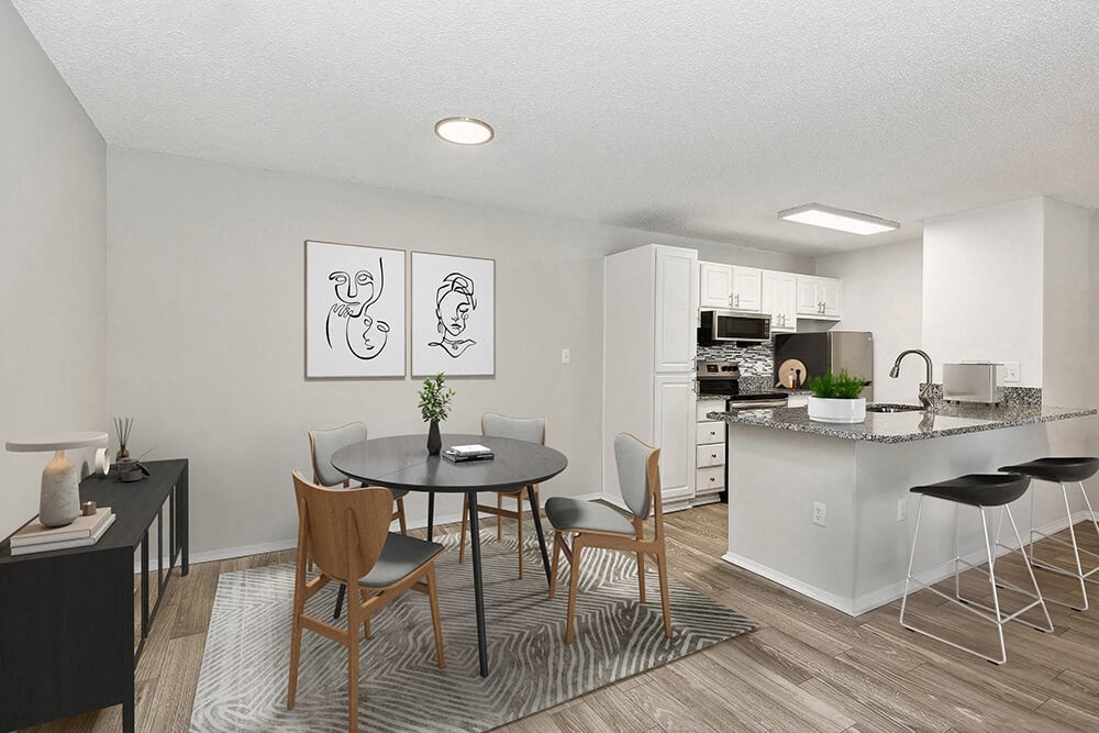 Model Dining Room with Wood-Style Flooring and View of Kitchen at Seven Lakes at Carrollwood Apartments in Tampa, FL.