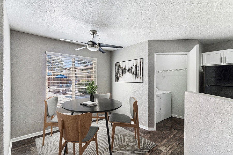 Model Dining Room with Wood-Style Flooring and View of Kitchen at Topaz Springs Apartments in Las Vegas, NV.