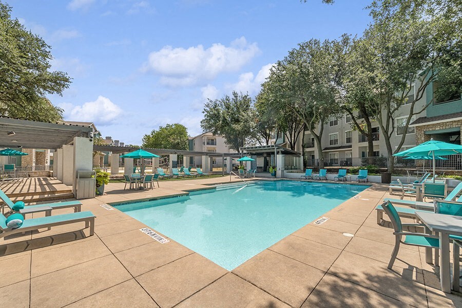 Community Swimming Pool with Pool Furniture at Essence Apartments in Dallas, TX.