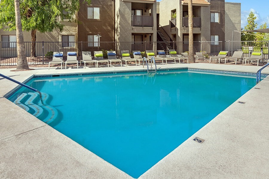 Community Swimming Pool with Pool Furniture at Saddle Ridge Apartments in Tucson, AZ.