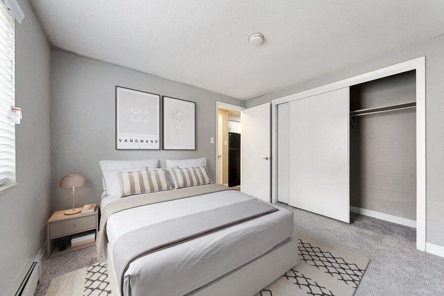 Model bedroom with sliding door closet at Esprit Cherry CreekApartments in Glendale, CO