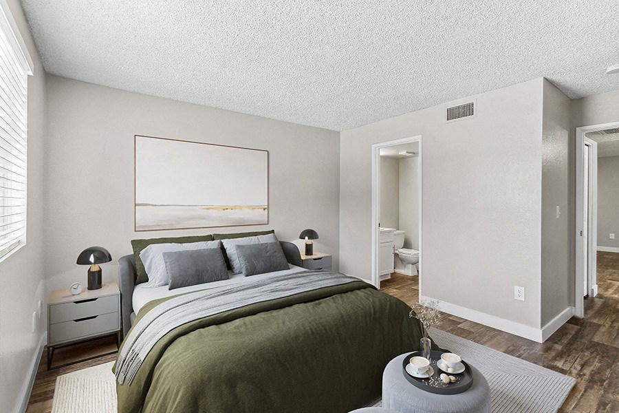 Model Bedroom with Wood-Style Flooring and Attached Bathroom at Meadow Ridge Apartments in Las Vegas, NV.
