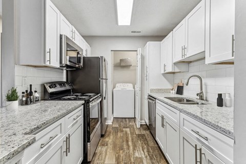 an all white kitchen with marble counter tops and white cabinets