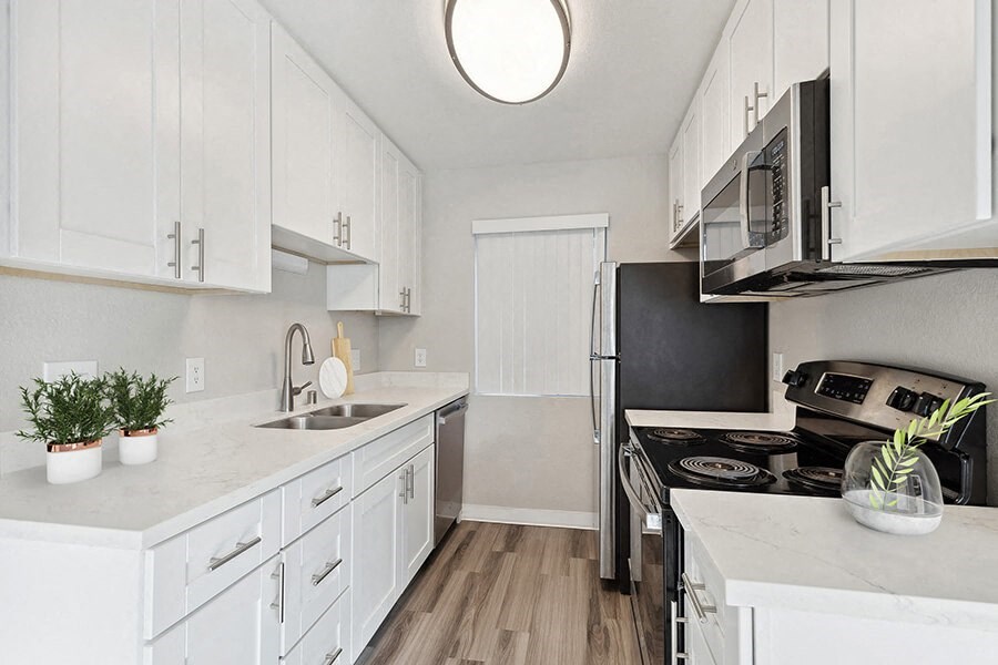 Model Kitchen with White Cabinets and Wood-Style Flooring at Bridges on Sunset Apartments in Suisun City, CA.
