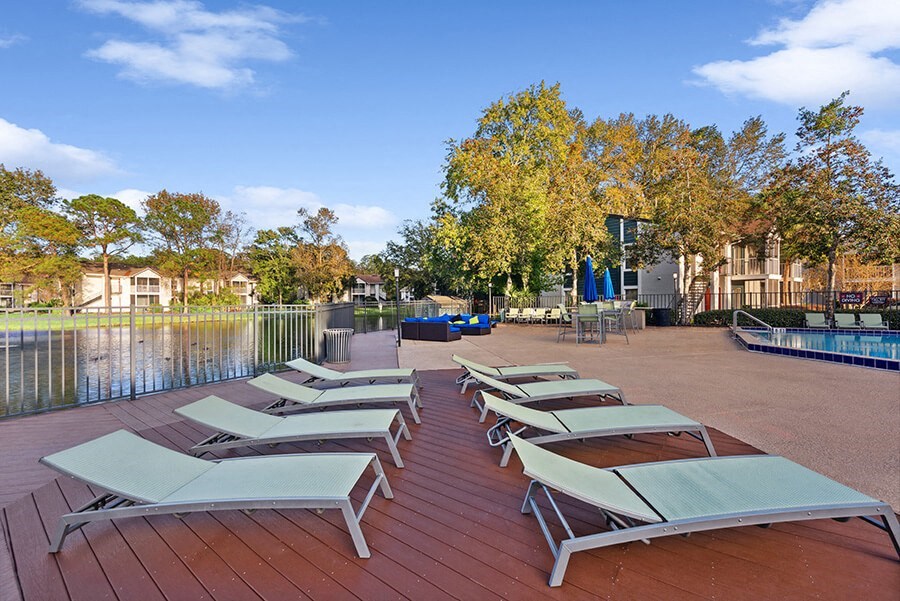 Outdoor Pool Deck Area with Pool Furniture at Vue at Baymeadows Apartments in Jacksonville, FL.