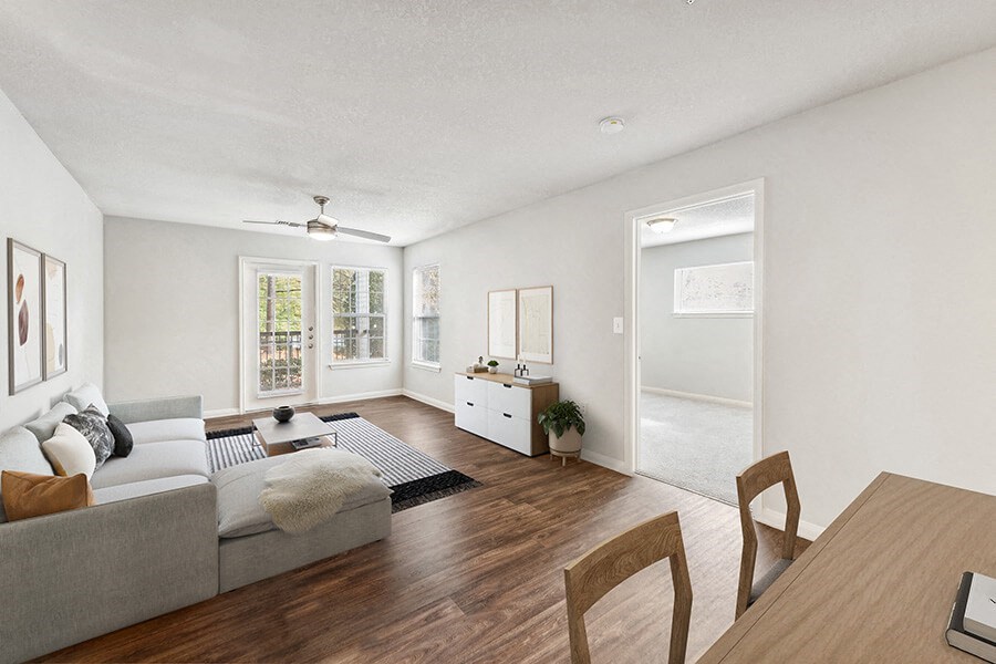 Model Living Room with Wood-Style Flooring and Patio Accessibility at Lake Cameron Apartments located in Apex, NC.