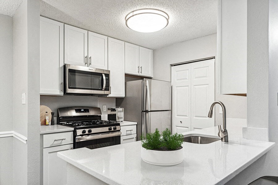 Model Kitchen with White Cabinets and Wood-Style Flooring at Commons at Haynes Farm Apartments in Shrewsbury, MA.