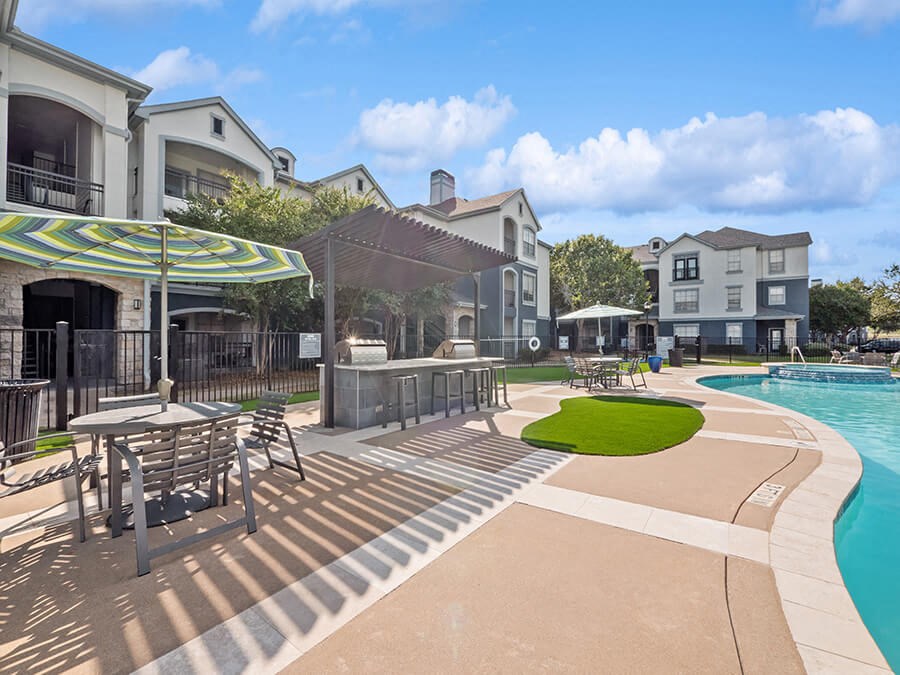 Community Swimming Pool with Pool Furniture at Park West Apartments located in Houston, TX.
