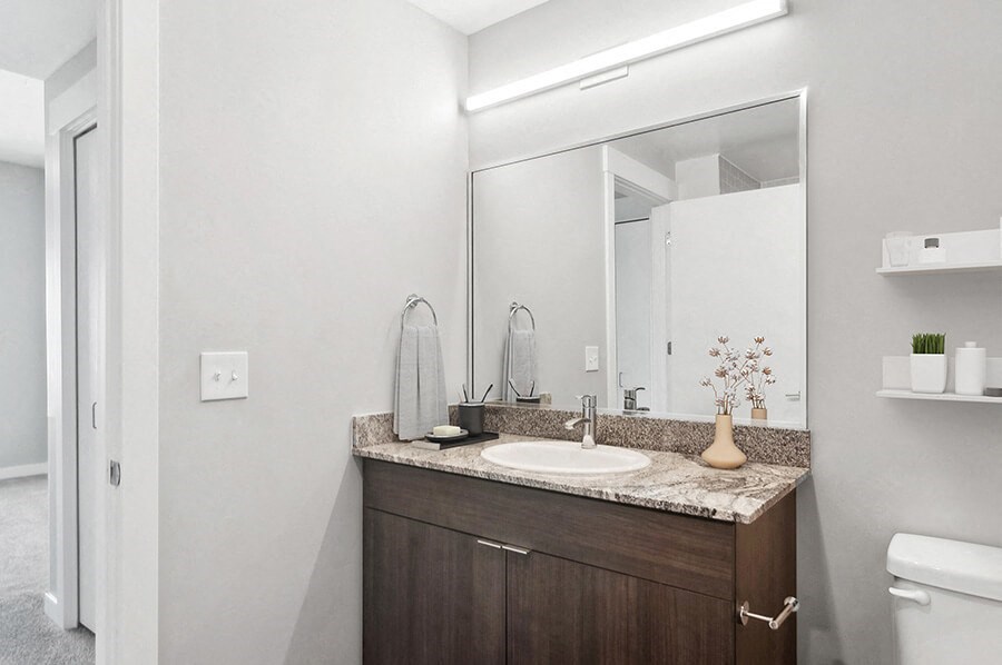 Model Bathroom with Wood-Style Flooring and Dark Oak Cabinets at Seven Skies Apartments located in Sandy, UT.