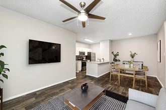 Model Living Room and Dining Room Area with Wood-Style Flooring at Dallas North Park Apartments in Dallas, TX.