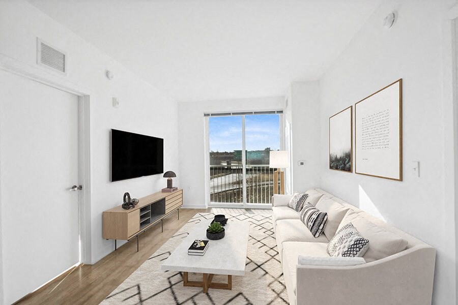 Model Living Room with Wood-Style Flooring and Patio Accessibility at Stella Apartments located in New Carrollton, MD.