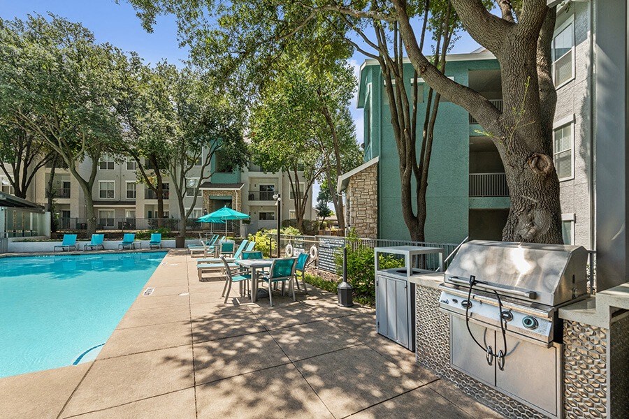 Community Swimming Pool with Pool Furniture at Essence Apartments in Dallas, TX.